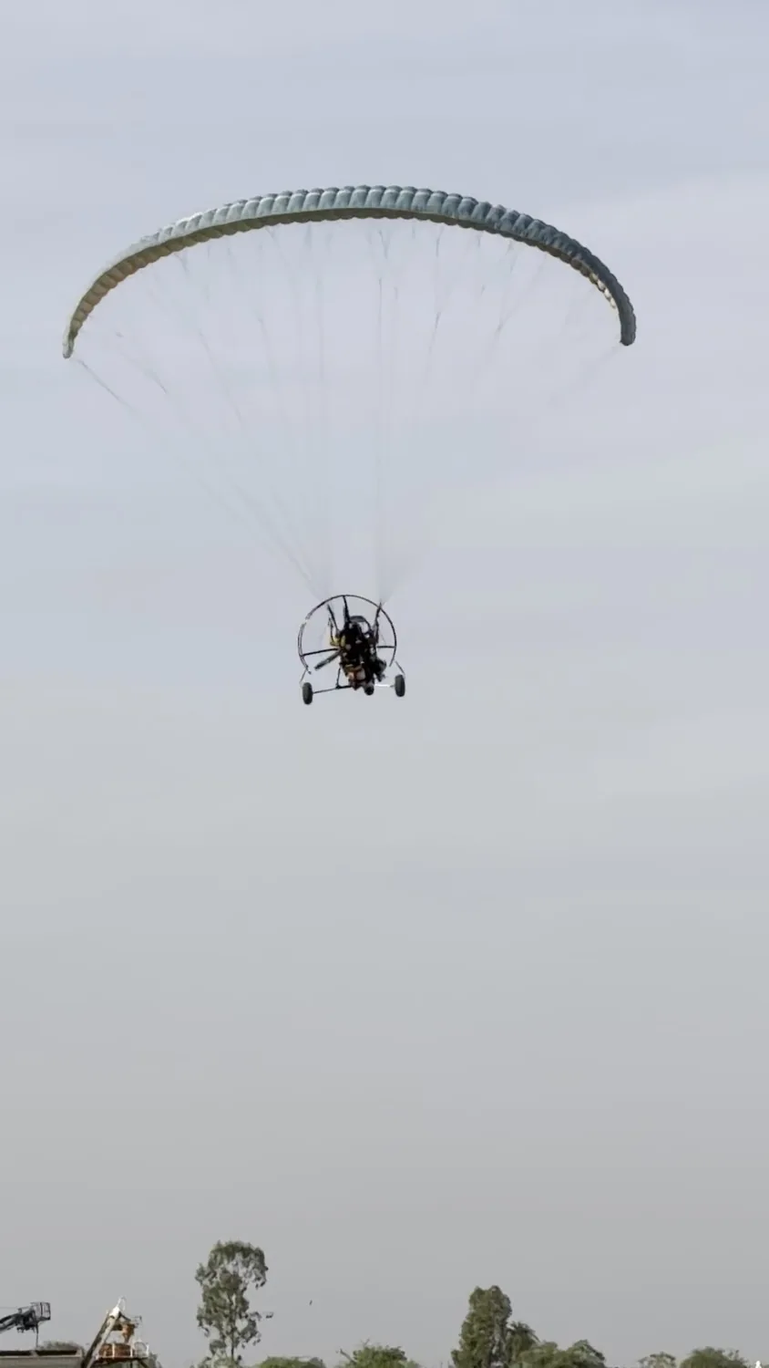 Motor paragliding trike flying in the open sky
