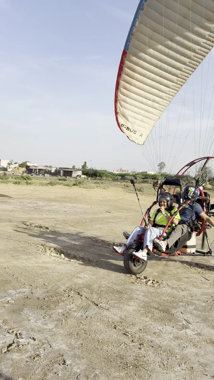 Motor paragliding trike moving on the ground with canopy visible