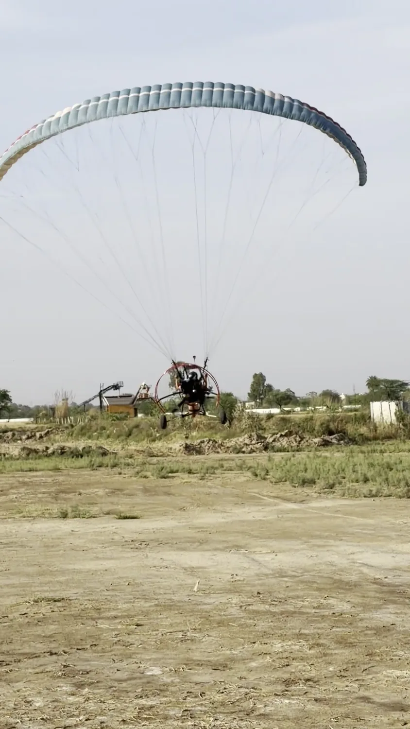Motor paragliding trike moving across the open launch field