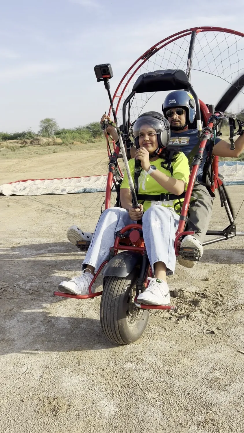 Participant seated with pilot in a motor paragliding trike before the ride